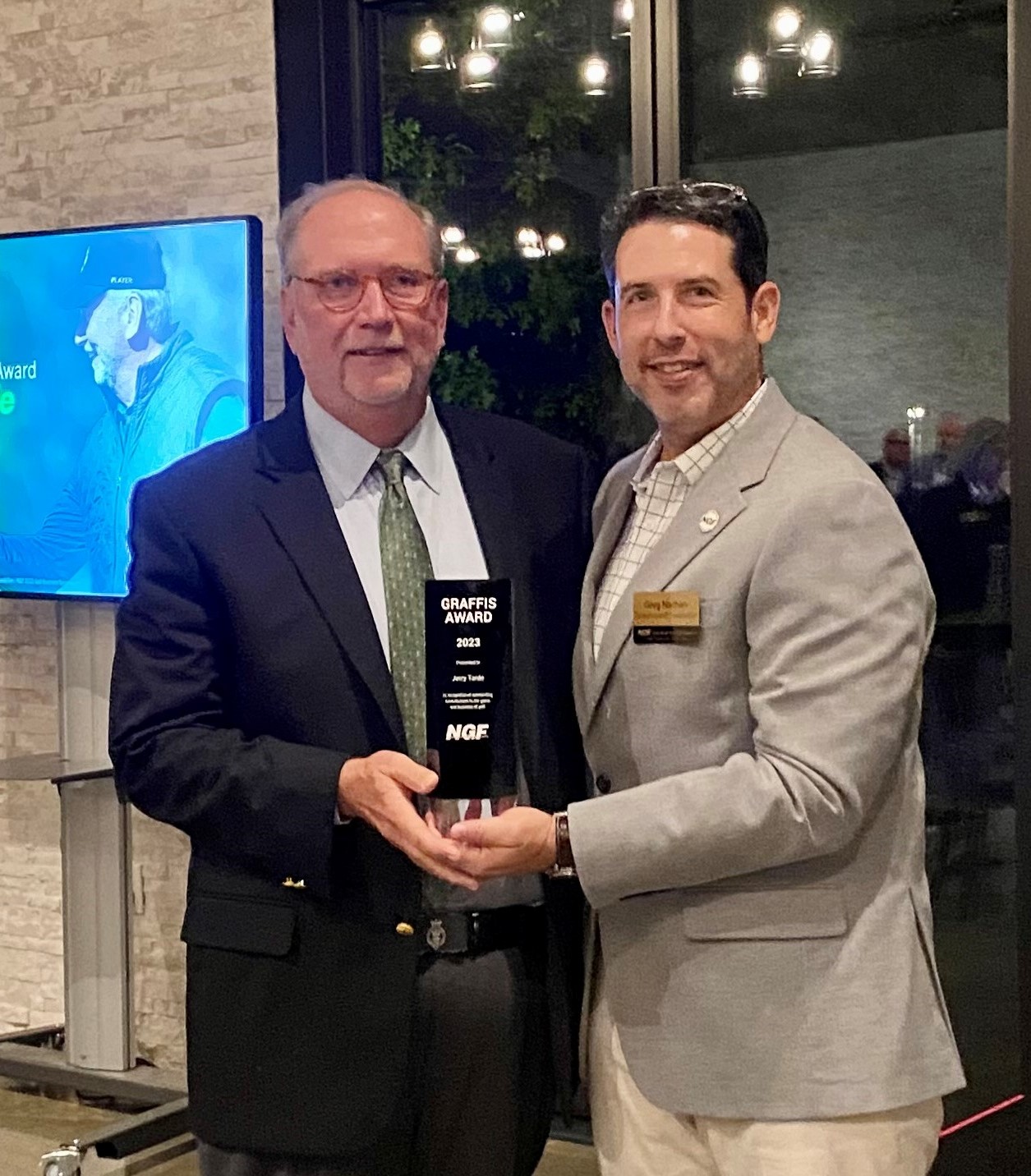 Golf Digest's Jerry Tarde (left) receives the NGF's 2023 Graffis Award from Greg Nathan.